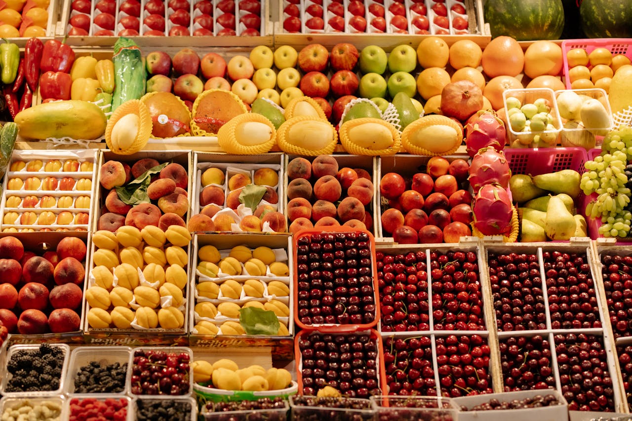 Colorful arrangement of fresh fruits at a bustling market stall, showcasing seasonal produce.